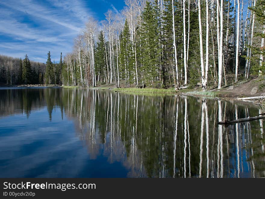 Striking sky accenting clear mountain lake with forest. Striking sky accenting clear mountain lake with forest