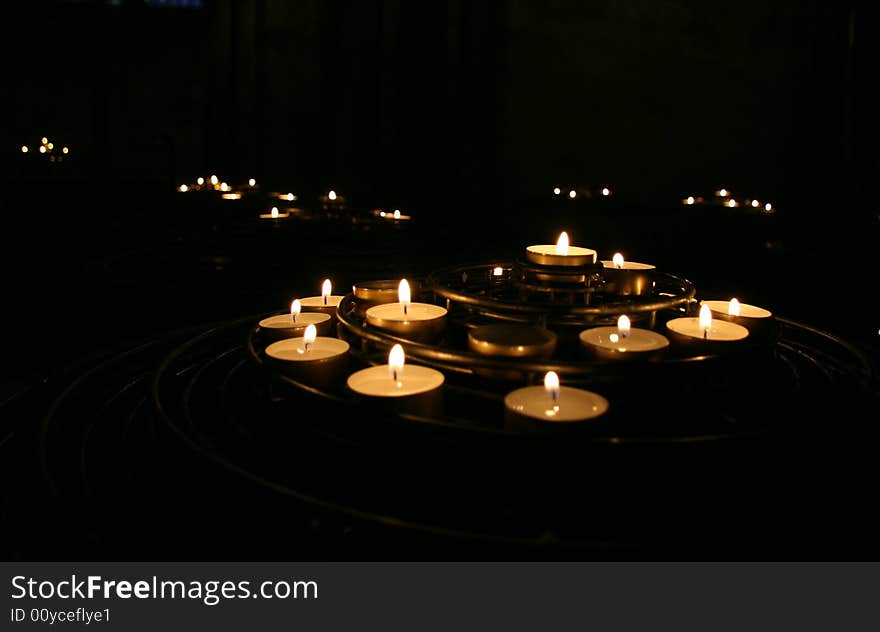 Candles burning in darkness inside a church. Candles burning in darkness inside a church