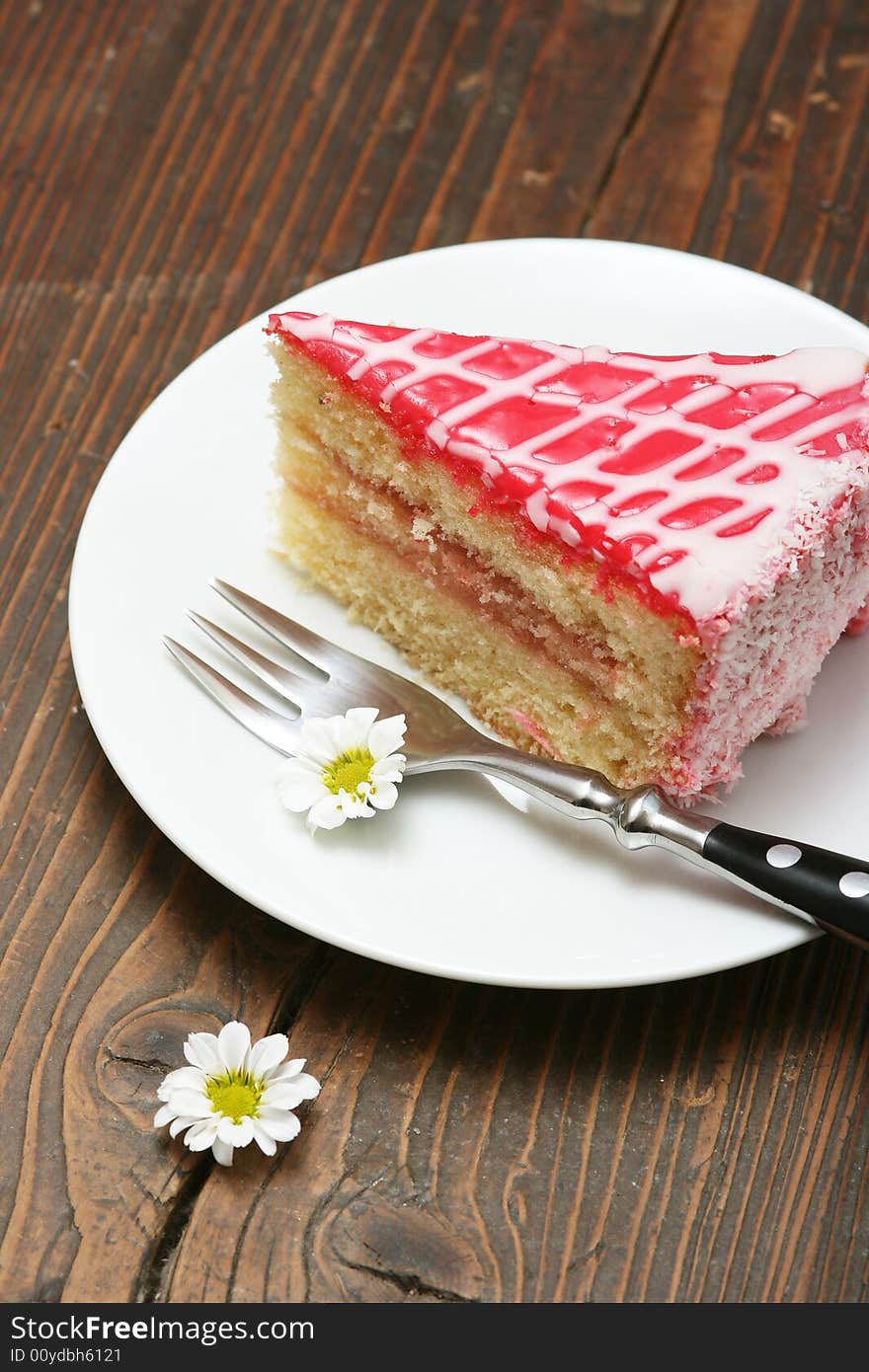 A slice of a cream cake and flowers.