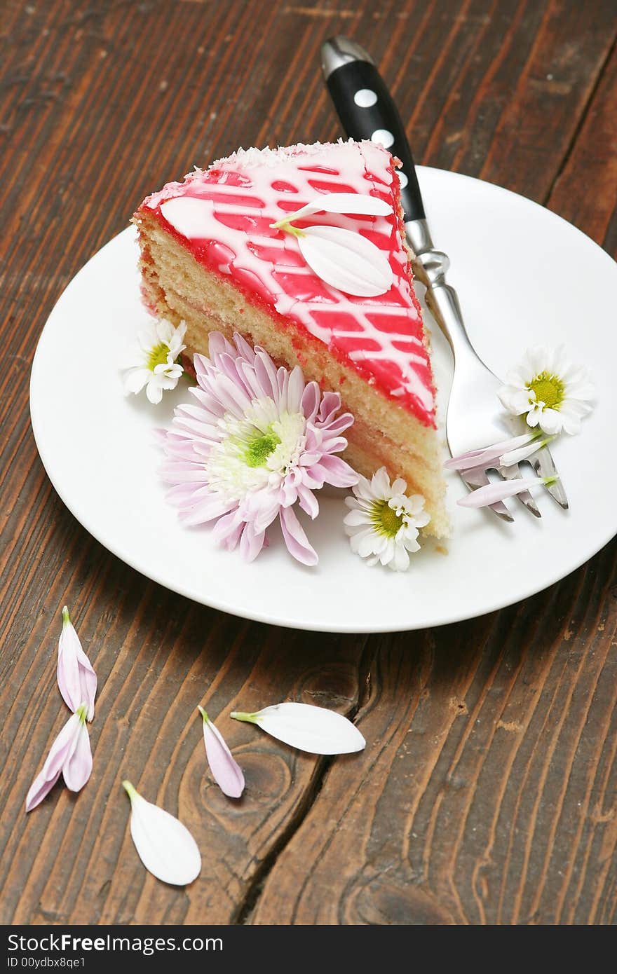 A slice of a cream cake and flowers.