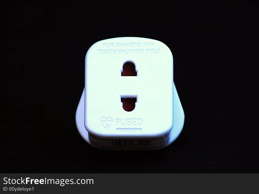 Shot of a white adapter plug aganst a black background. Shot of a white adapter plug aganst a black background