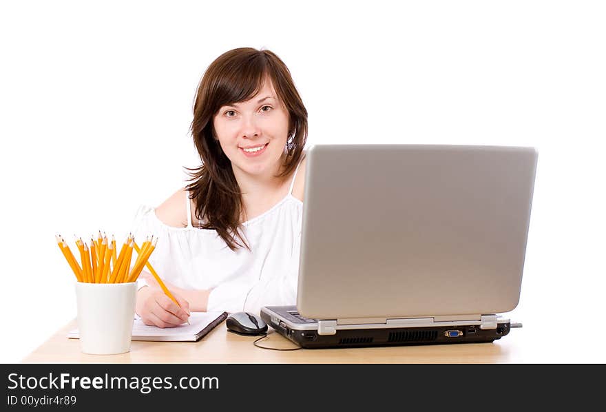 Young female office worker, laptop, pencils, notebook on desk, isolated. Young female office worker, laptop, pencils, notebook on desk, isolated