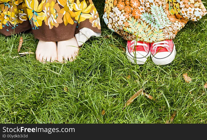 Woman feets under dress over the grass. Woman feets under dress over the grass