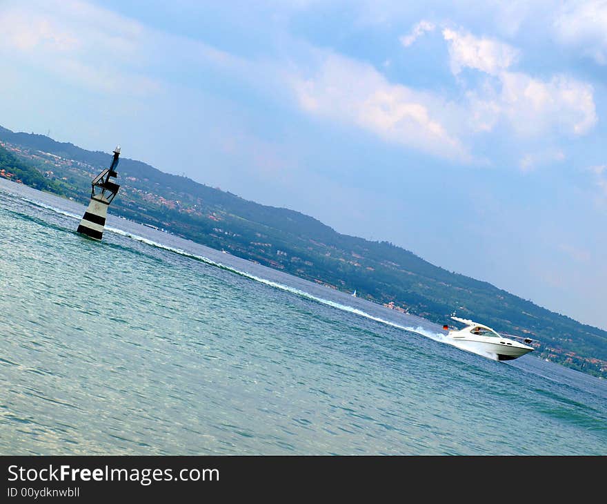 An original shot of a little lighthouse and a speedboat. An original shot of a little lighthouse and a speedboat