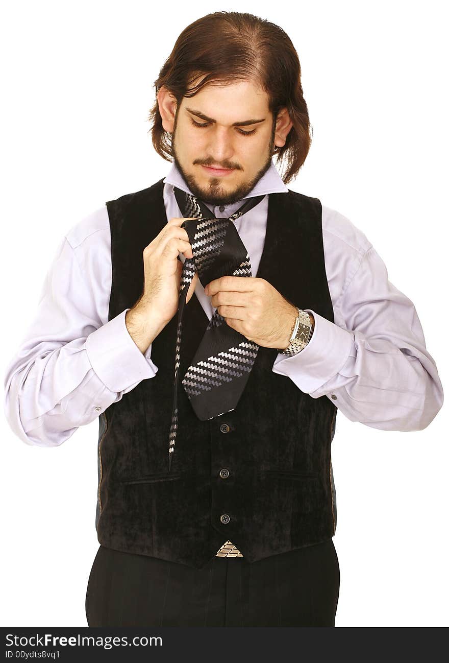 Young man wearing vest, getting ready to party and finishing his tie. Young man wearing vest, getting ready to party and finishing his tie