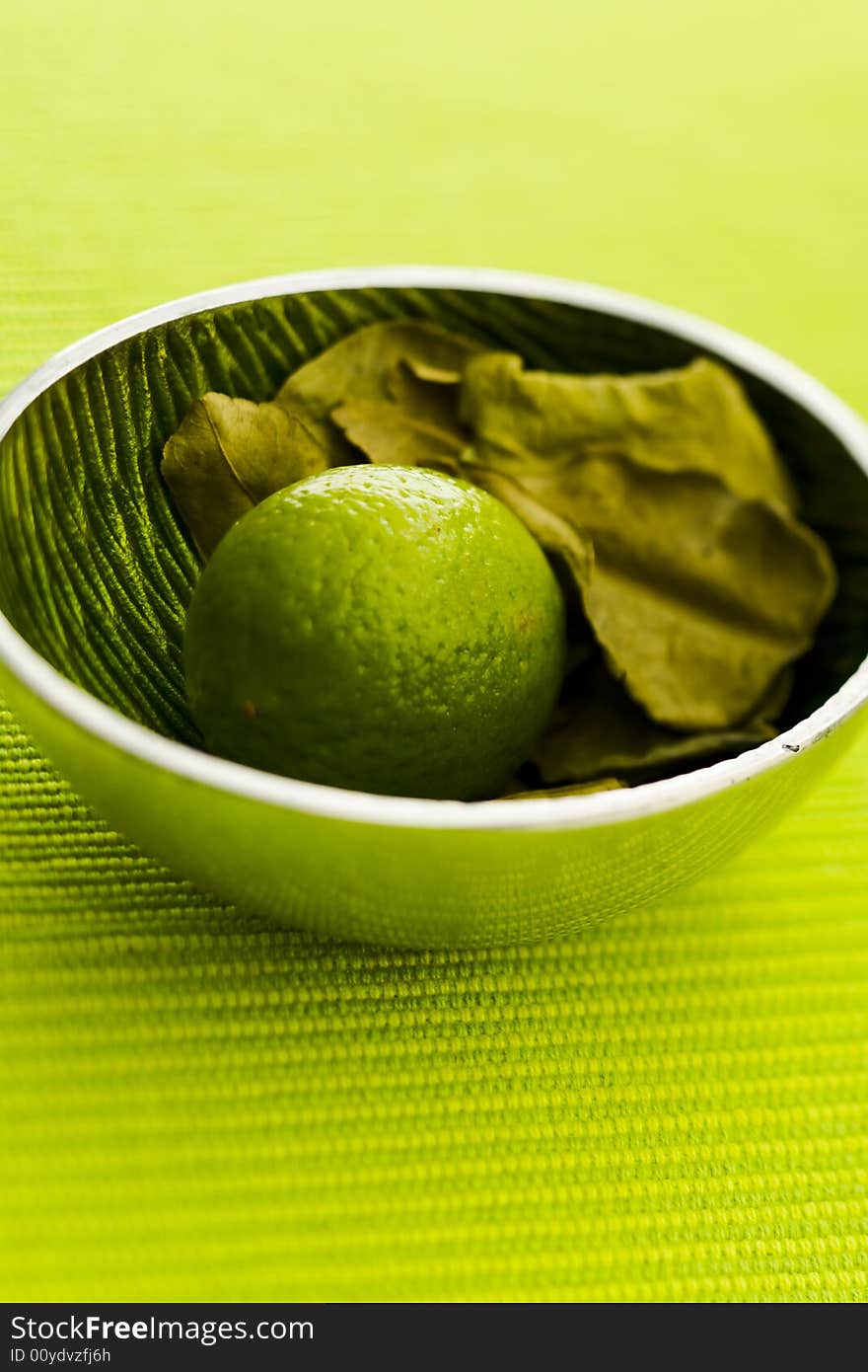 Lime with kafir leaves on the green table