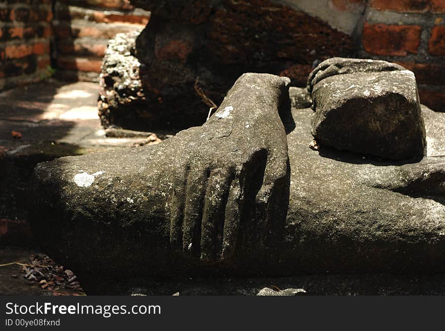 In Thailand the city of Ayutthaya was founded in 1350 today is an impressive archaeological park; here a view of the Wat Ratburana or Ratchaburana ruins built in 1424 with a detail of an ancient statue of Buddha. In Thailand the city of Ayutthaya was founded in 1350 today is an impressive archaeological park; here a view of the Wat Ratburana or Ratchaburana ruins built in 1424 with a detail of an ancient statue of Buddha