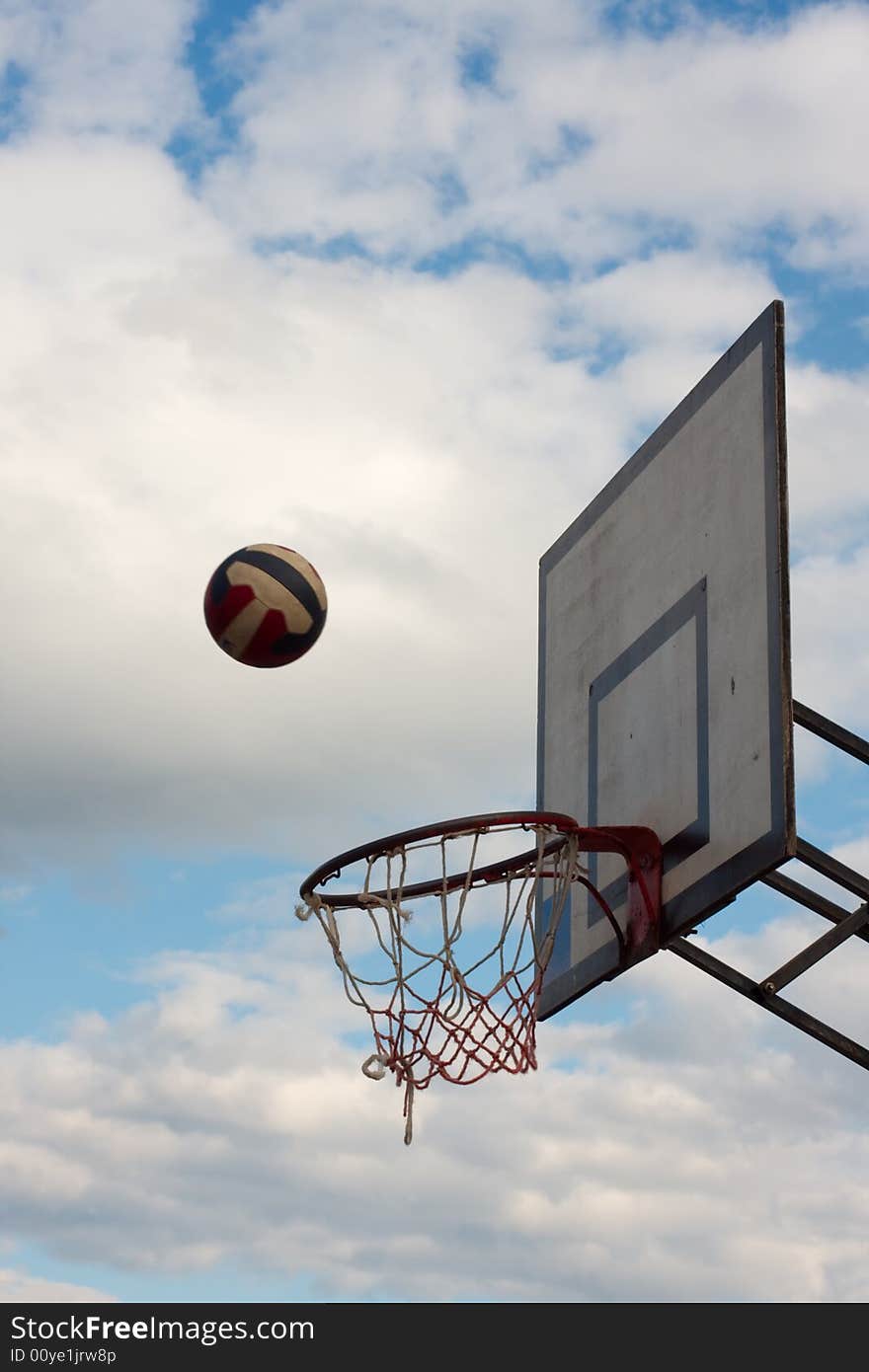 Striped ball falling towards the hoop. Striped ball falling towards the hoop