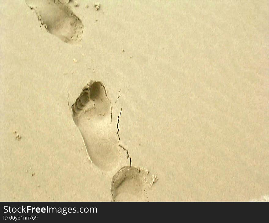 A human footprint in the sand on beach. A human footprint in the sand on beach.