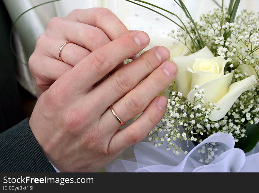 Two rings on fingers newly married, a bouquet of yellow roses in a hand. Two rings on fingers newly married, a bouquet of yellow roses in a hand