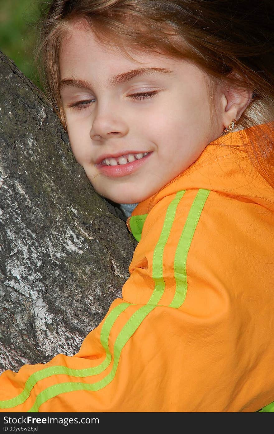 Little girl with a happy smile on her face hugging a tree. Little girl with a happy smile on her face hugging a tree