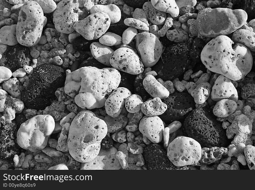 Black and white photograph of black lava and white coral pebbles, rounded by ocean waves, on a Hawaiian beach. Black and white photograph of black lava and white coral pebbles, rounded by ocean waves, on a Hawaiian beach