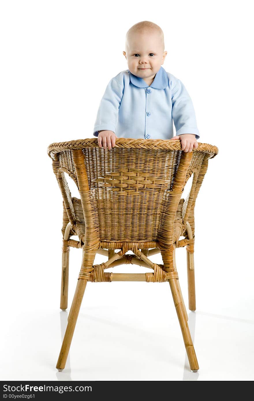 A photo of a baby boy, standing on chair