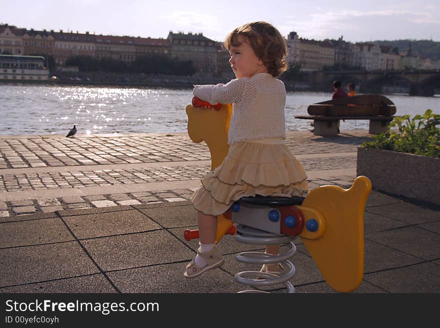 A playful little girl is rocking on the playground. A playful little girl is rocking on the playground.