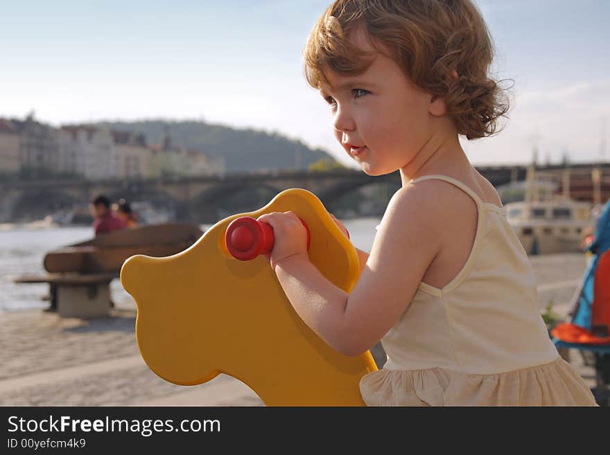 A playful little girl is rocking on the playground. A playful little girl is rocking on the playground.