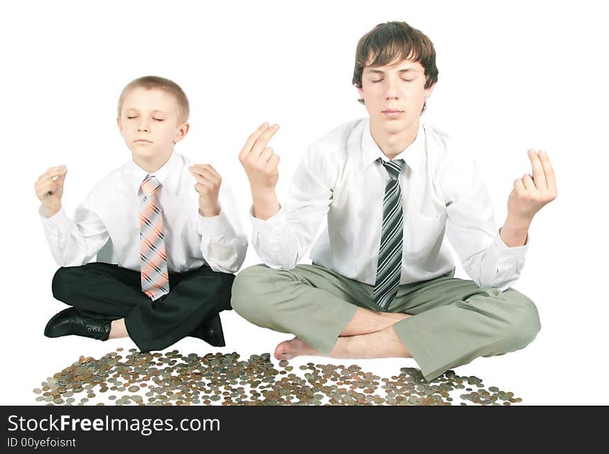 Two boys meditate sitting near money. Two boys meditate sitting near money.