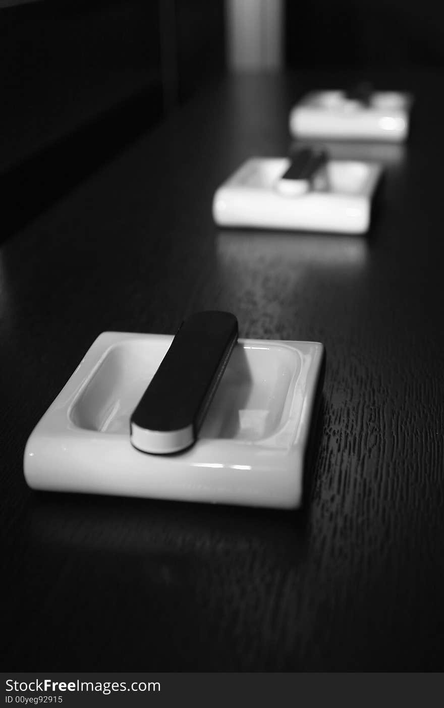 White ashtrays and boxes of matches on a black table at restaurant.