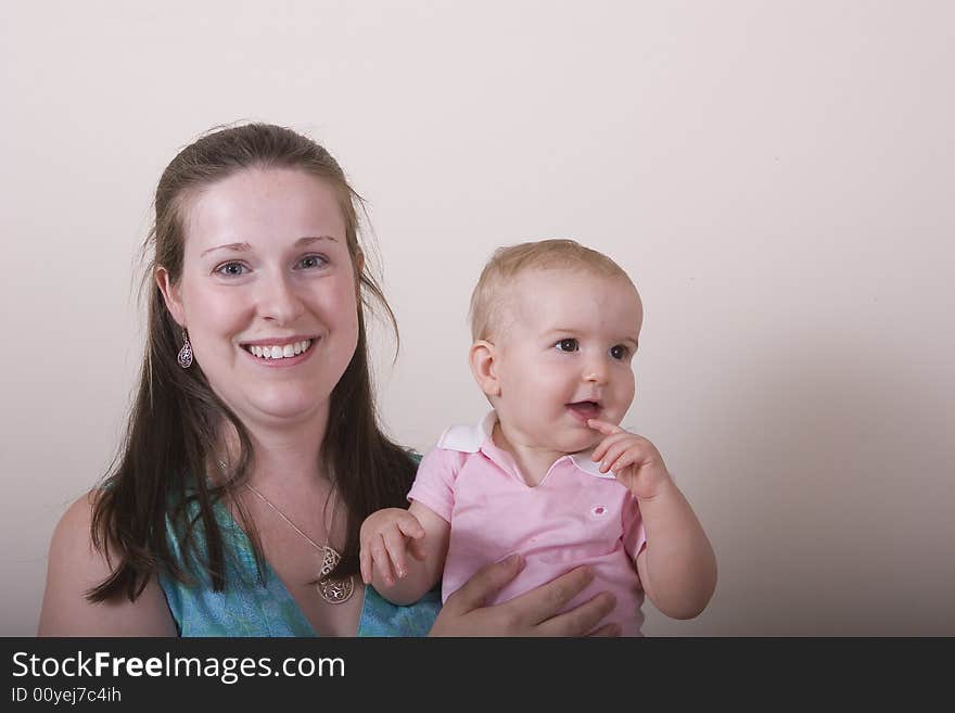 A young woman with her baby daughter looking away. A young woman with her baby daughter looking away