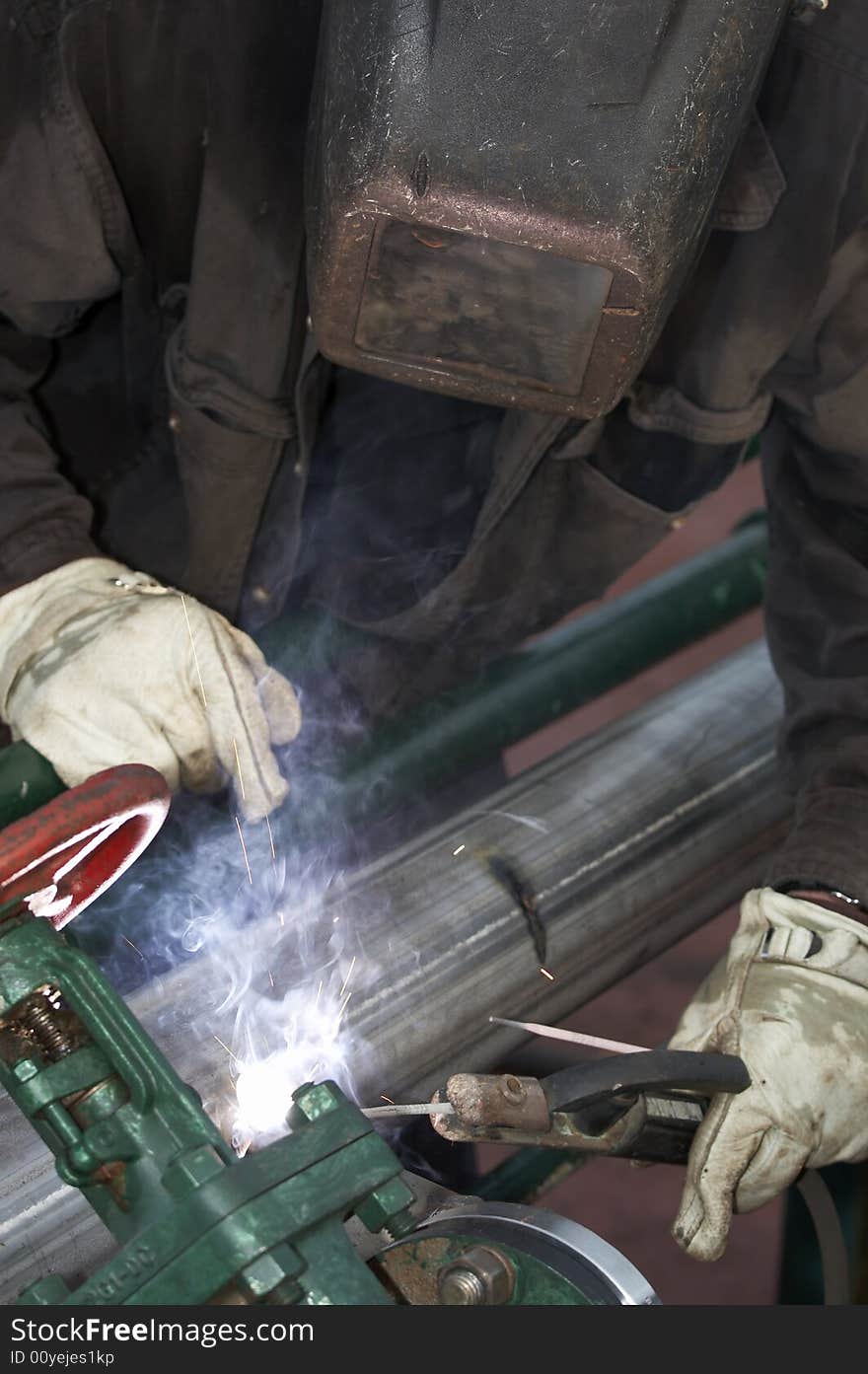 A welder working at shipyard during day shift. A welder working at shipyard during day shift