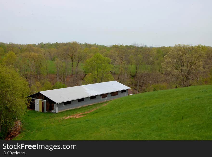 This is a storage barn on a hillside in West Virginia. Lots of green grass and other early spring colors.