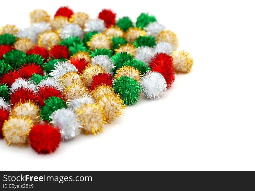 Pile of small sparkling festive deocation puff-balls on a white background. Pile of small sparkling festive deocation puff-balls on a white background