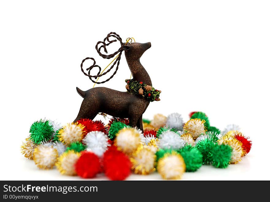 Reindeer ornament and colorful puff ball decorations over a white background. Reindeer ornament and colorful puff ball decorations over a white background