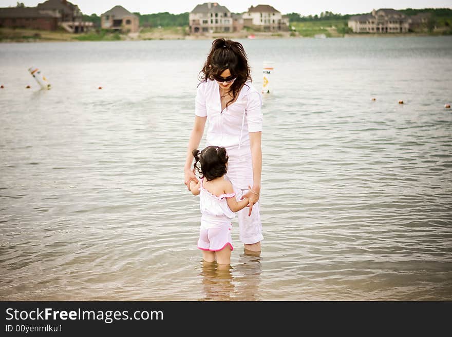 Mother and daughter holding hands at the beach