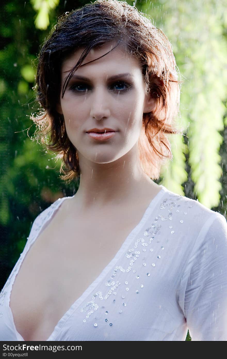 Brunette in see through blouse standing in the rain. Brunette in see through blouse standing in the rain