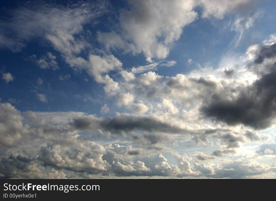 Puffy white clouds hang in a bright blue sky. Puffy white clouds hang in a bright blue sky.