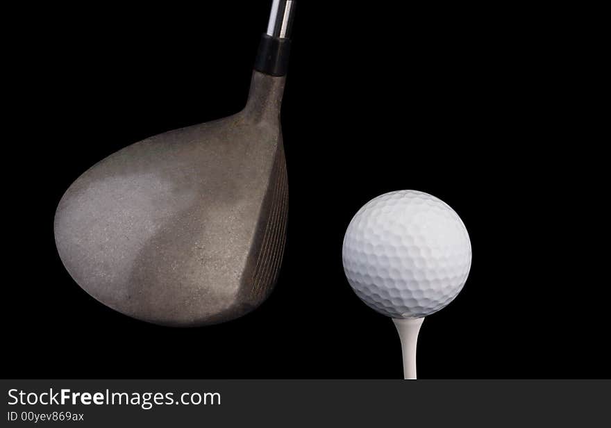 Golf ball on tee with driver w clipping path on black background