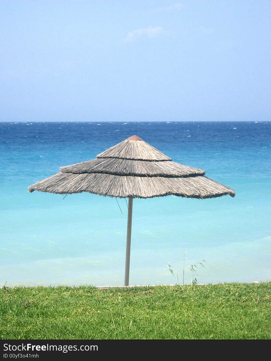 Sunshade on the grass beach of the sea. Sunshade on the grass beach of the sea