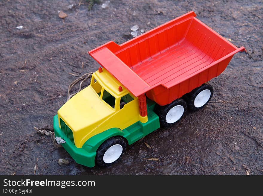 Baby toy dump truck in dirt (transportation)