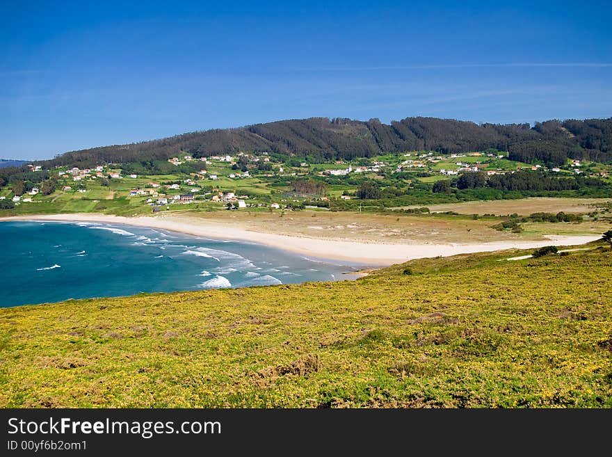 Distant view of village by the ocean with a beach, PANTIN