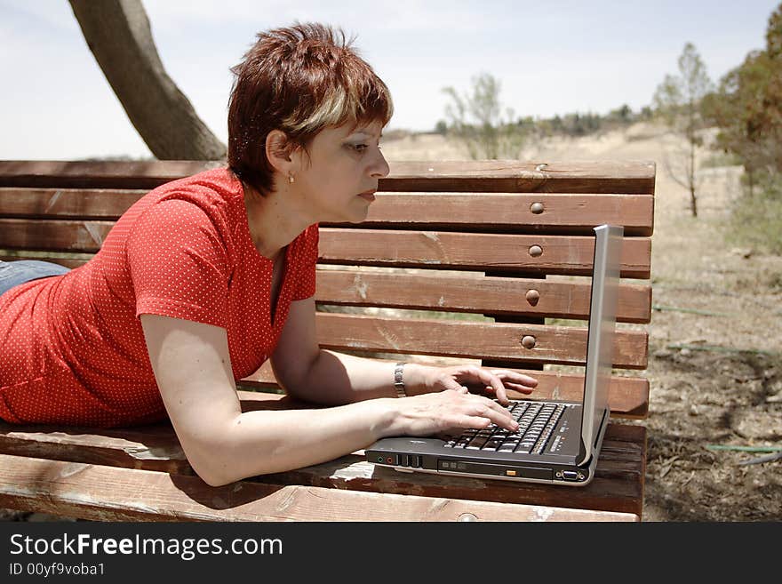 A young woman using a portable computer outside. A young woman using a portable computer outside