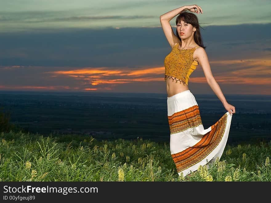 Young beautiful asian woman dancing at sunset, note there is some motion blur. Young beautiful asian woman dancing at sunset, note there is some motion blur