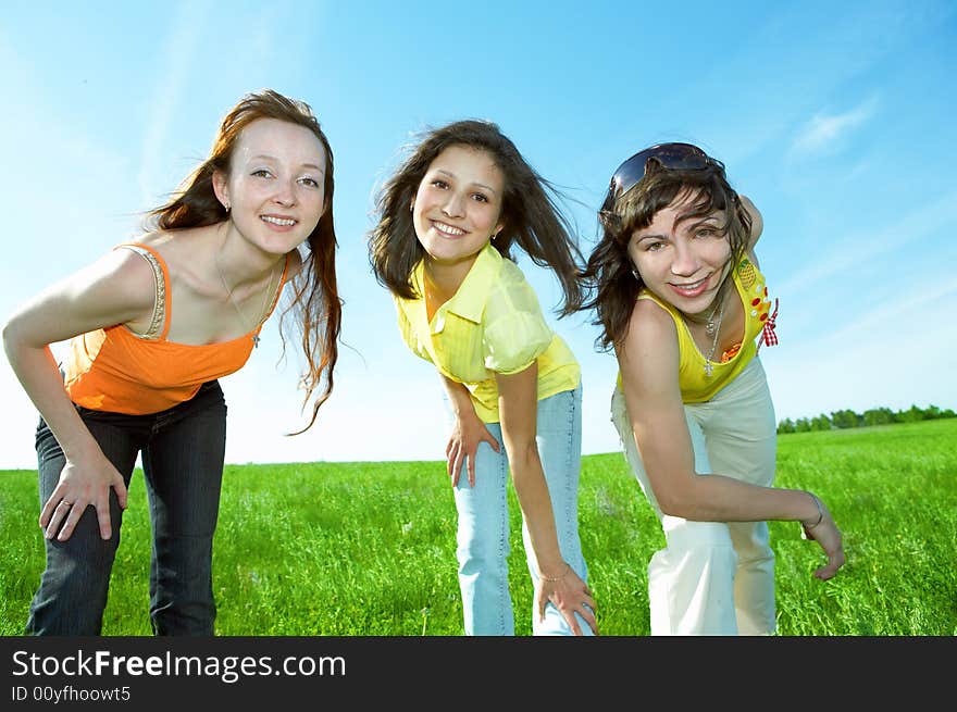 Three friend have fun in green field under blue sky