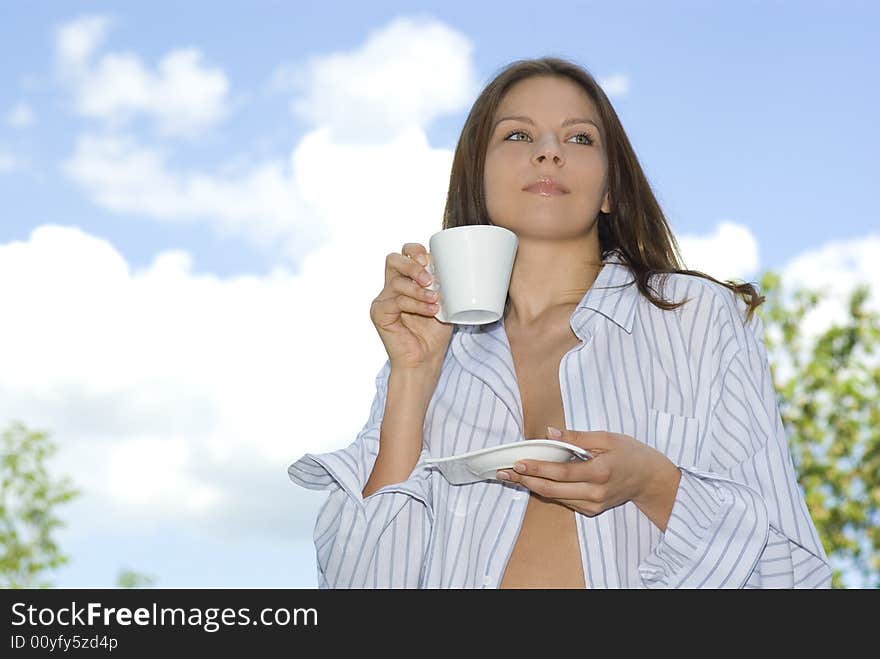 Young woman relaxing, drinking coffee at mountain outdoors.