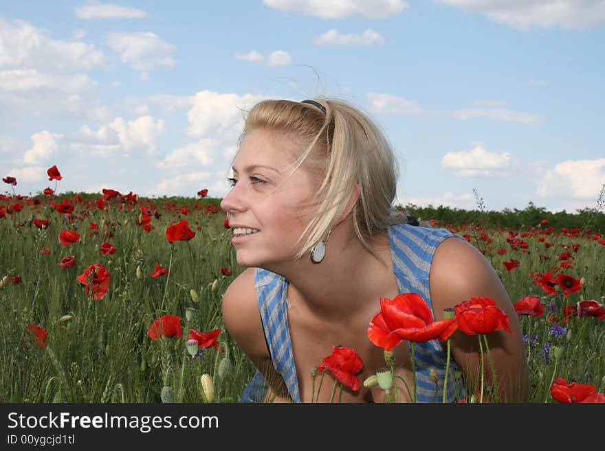 Young woman relaxing. sun weather and poppy field. Young woman relaxing. sun weather and poppy field