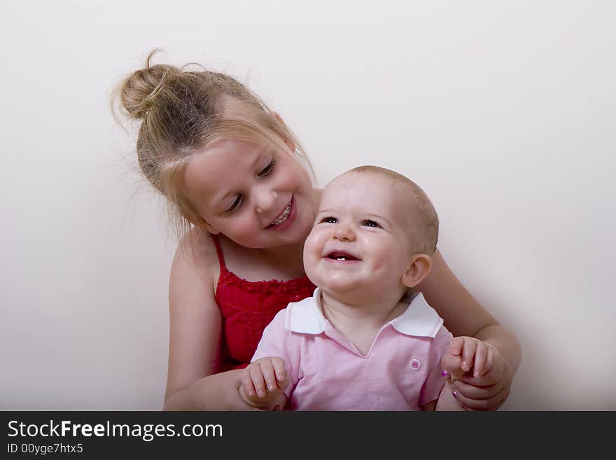 A young girl with a baby girl smiling and laughing. A young girl with a baby girl smiling and laughing