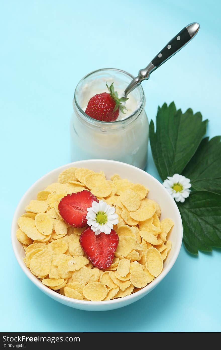 Closeup of open jar of organic yogurt and cornflakes,delicious strawberries with flowers. Closeup of open jar of organic yogurt and cornflakes,delicious strawberries with flowers.