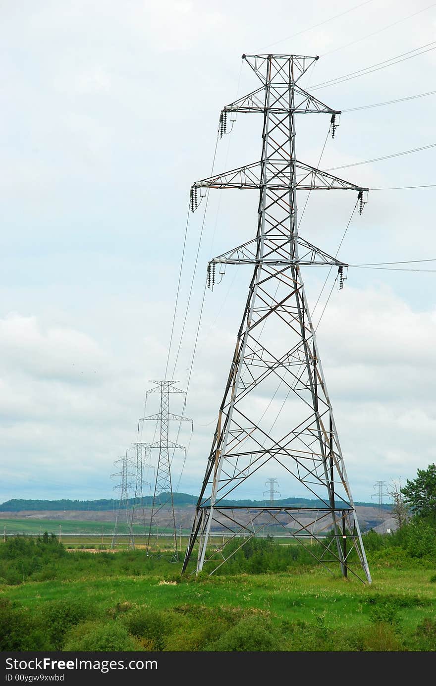 A perspective shot of a row of heavy industrial electrical pylons with room for copy space on the left. A perspective shot of a row of heavy industrial electrical pylons with room for copy space on the left.