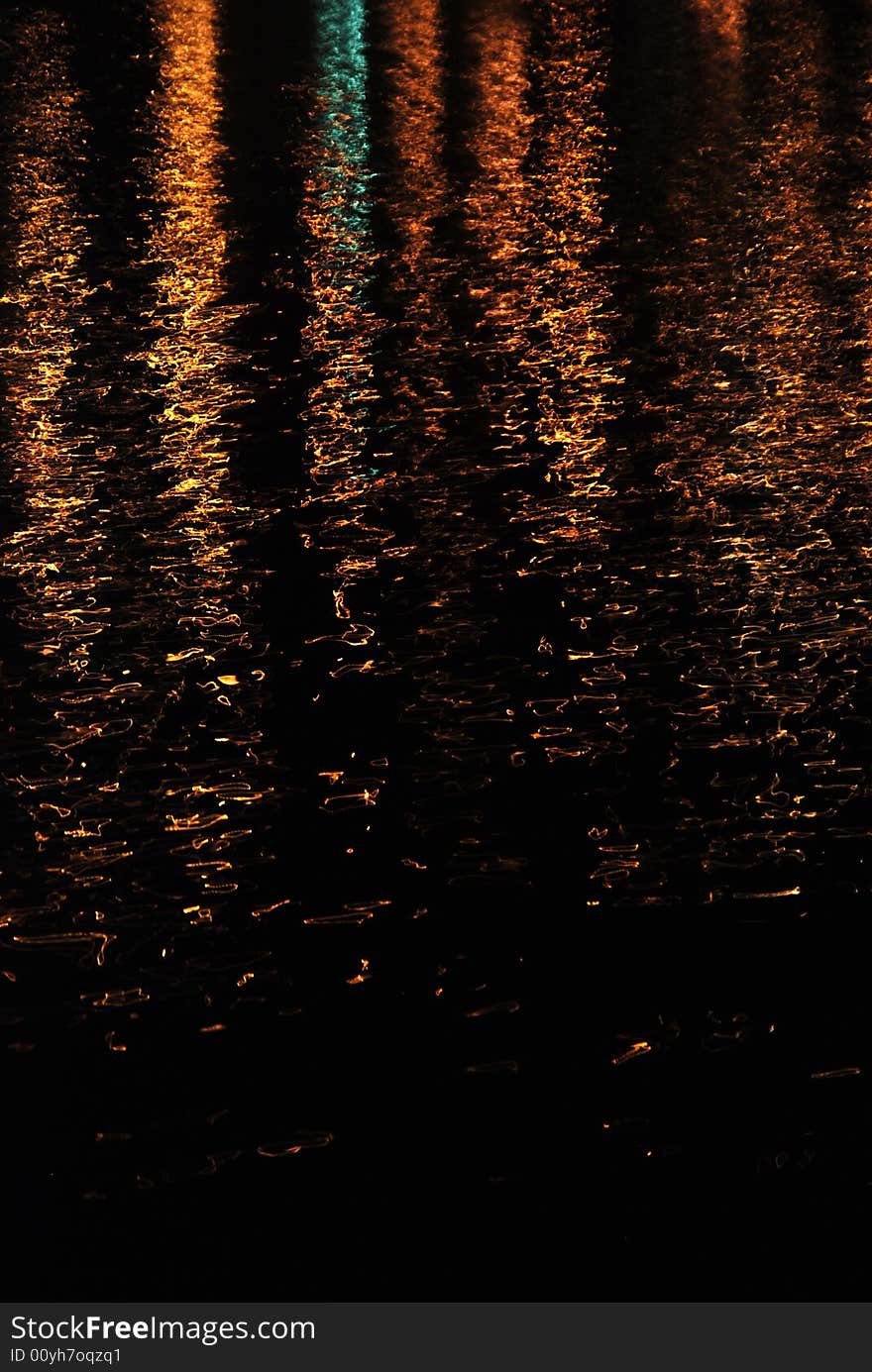 Orange lights reflecting on gently moving water. Orange lights reflecting on gently moving water