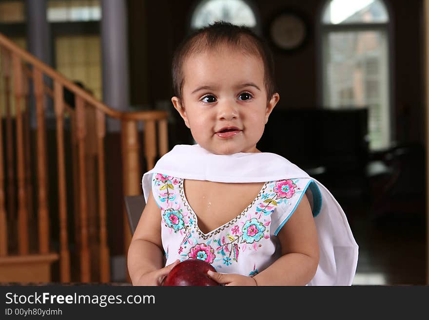 Little baby girl holding an apple