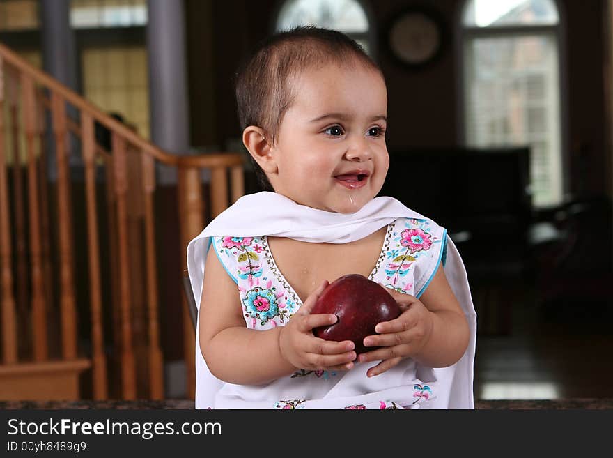 Little baby girl holding an apple