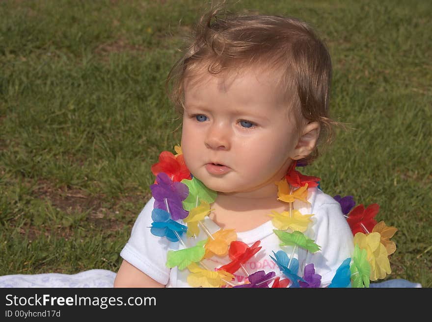 Little girl sitting on a grass