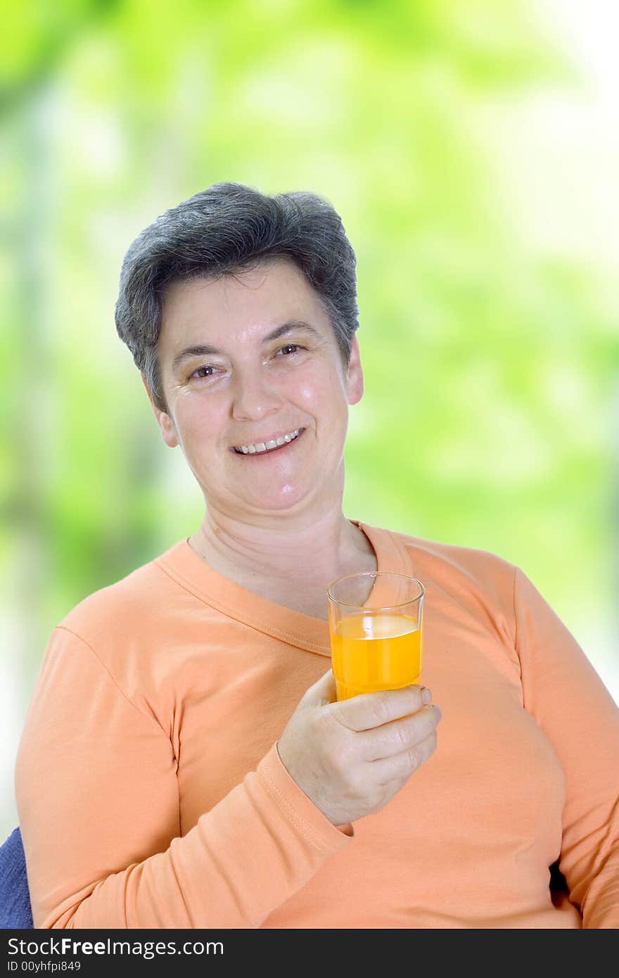 Senior woman enjoying glass of juice sitting on garden seat. Senior woman enjoying glass of juice sitting on garden seat