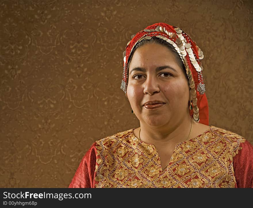 Muslim Woman in a Red Scarf in front of a Gold Wall