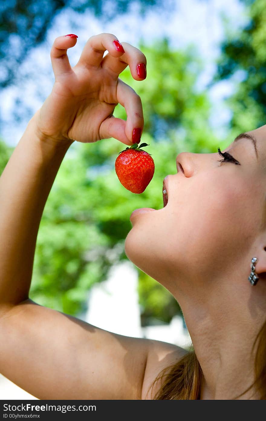 Portrait of the beautiful young girl with strawber