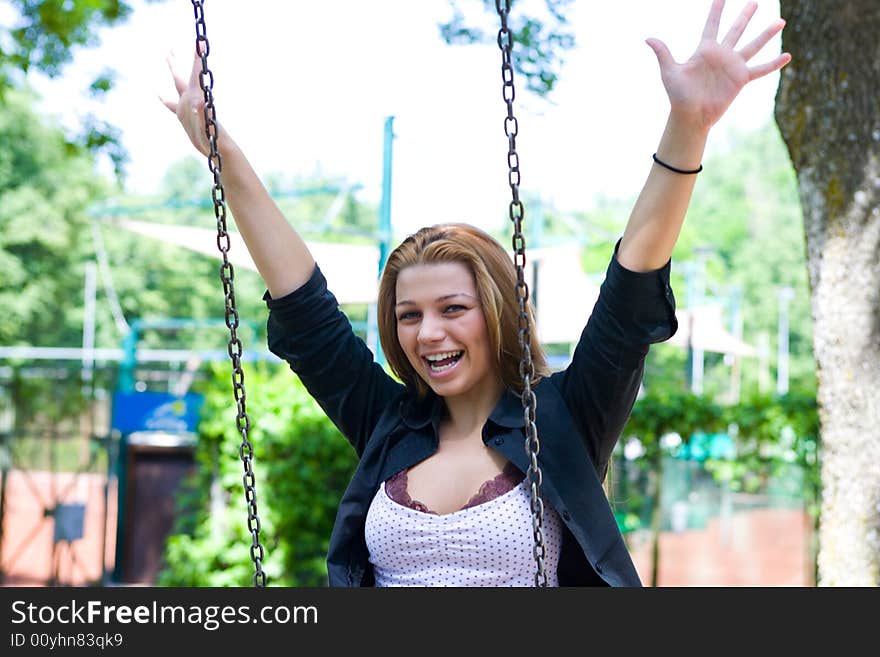 Portrait of the young girl on a swing