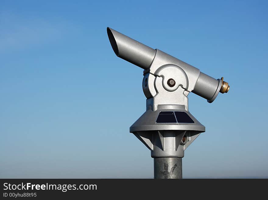 Spyglass pointing upwards against blue sky